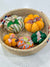 a wicker basket filled with small decorative pumpkins