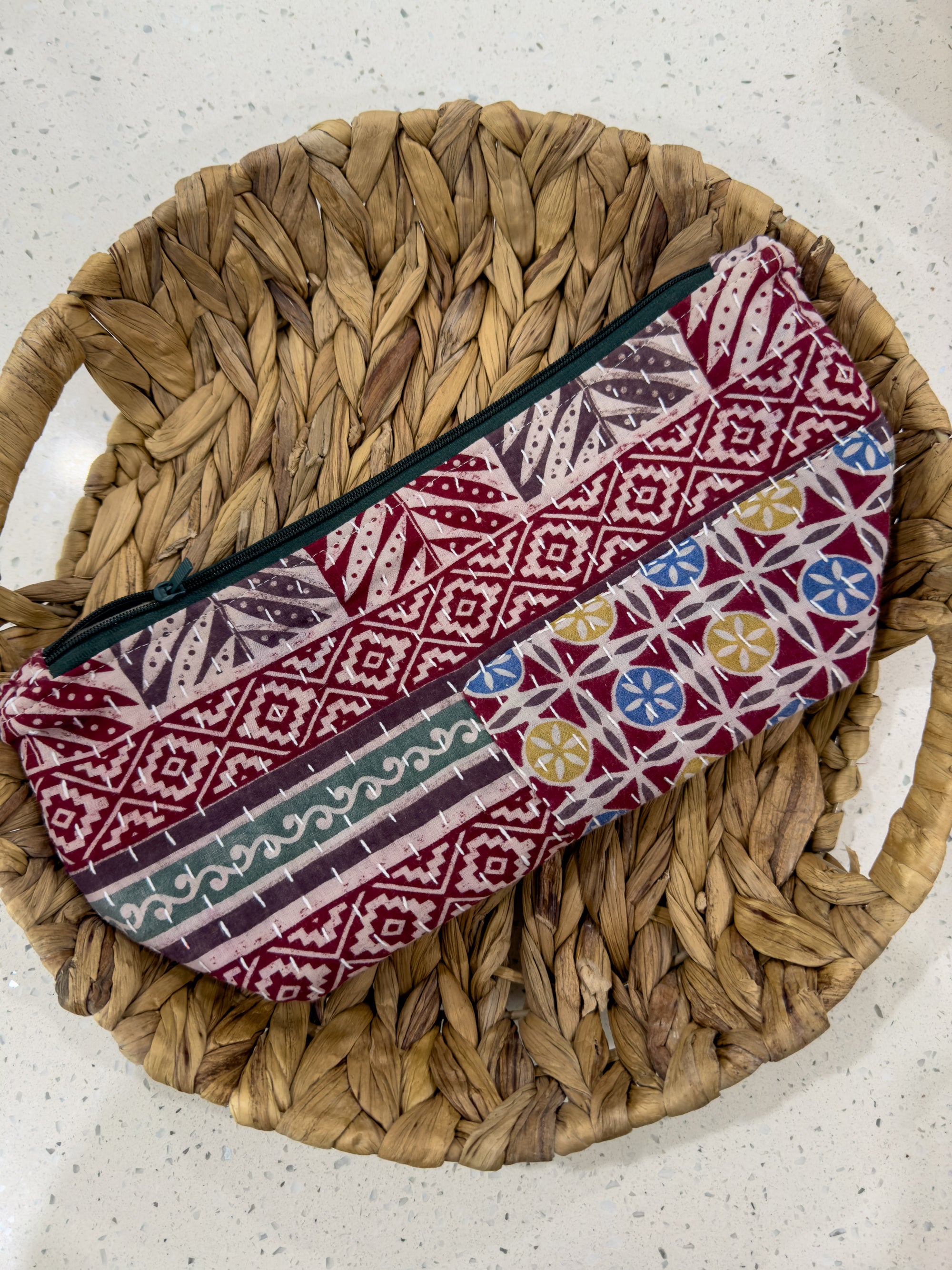 a woven basket with a red, white, and blue purse on top of it