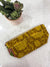 a yellow purse sitting on top of a table next to a potted plant