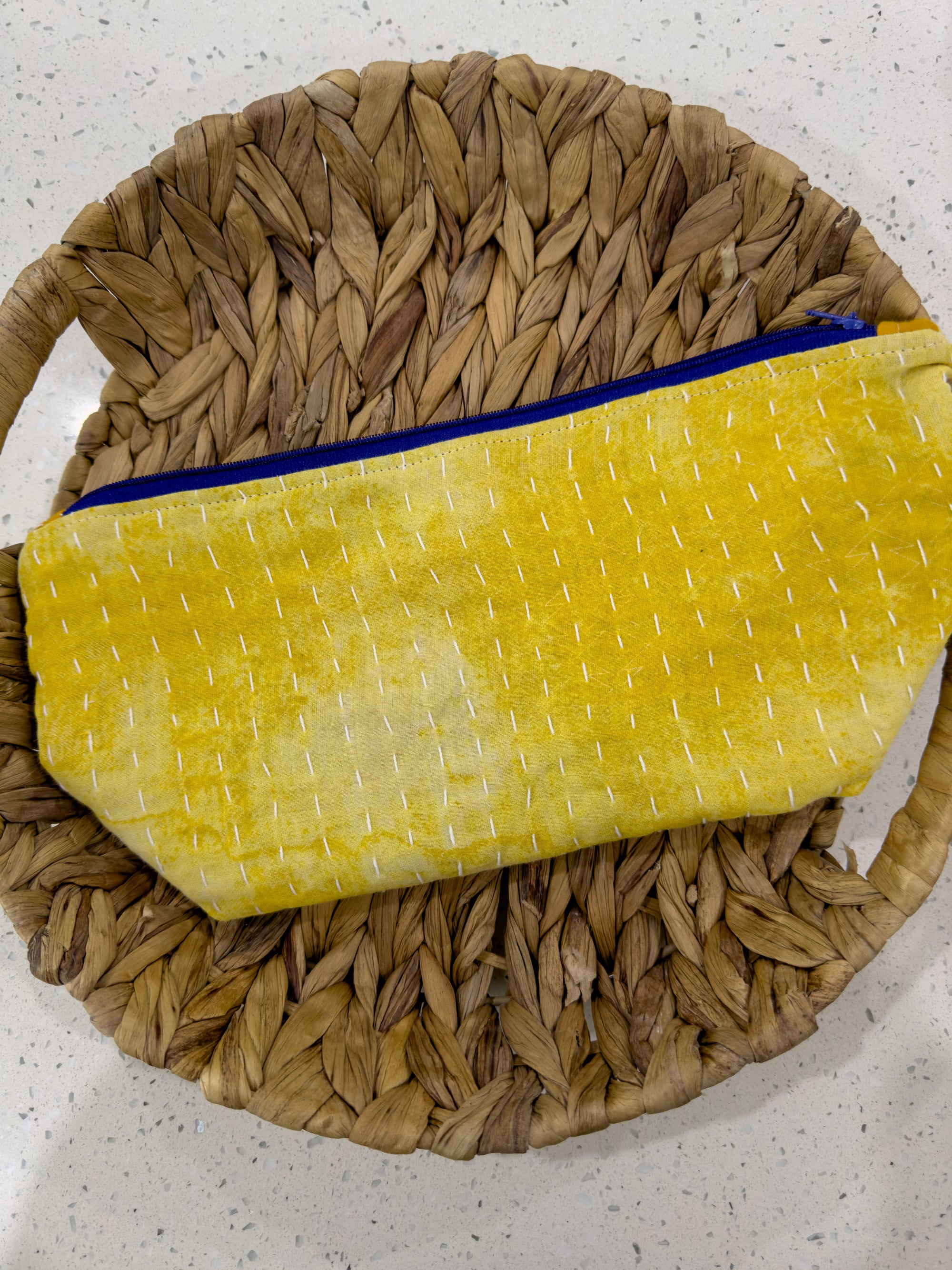 a yellow bag sitting on top of a woven basket