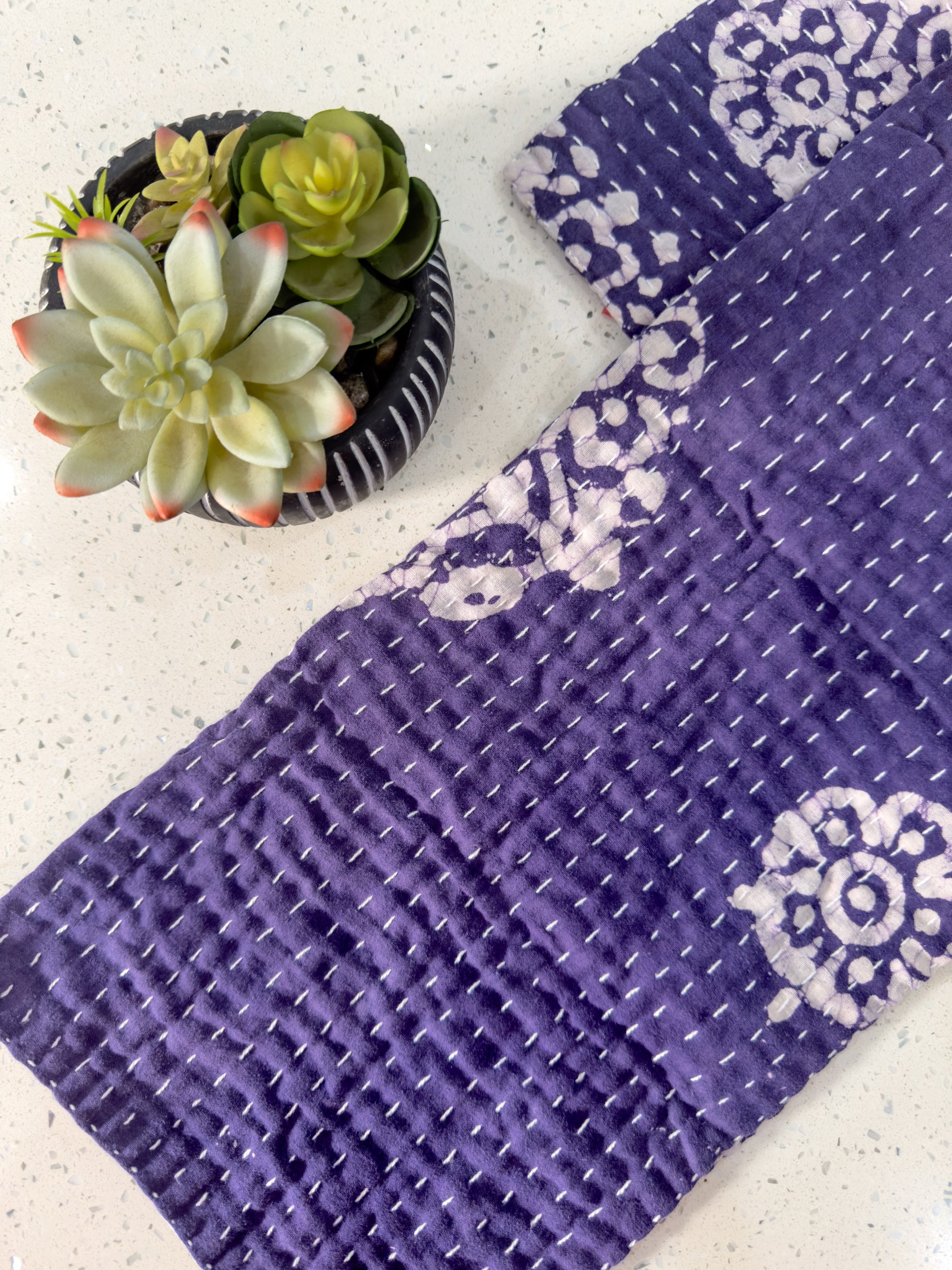 a potted plant sitting on top of a table next to a purple towel