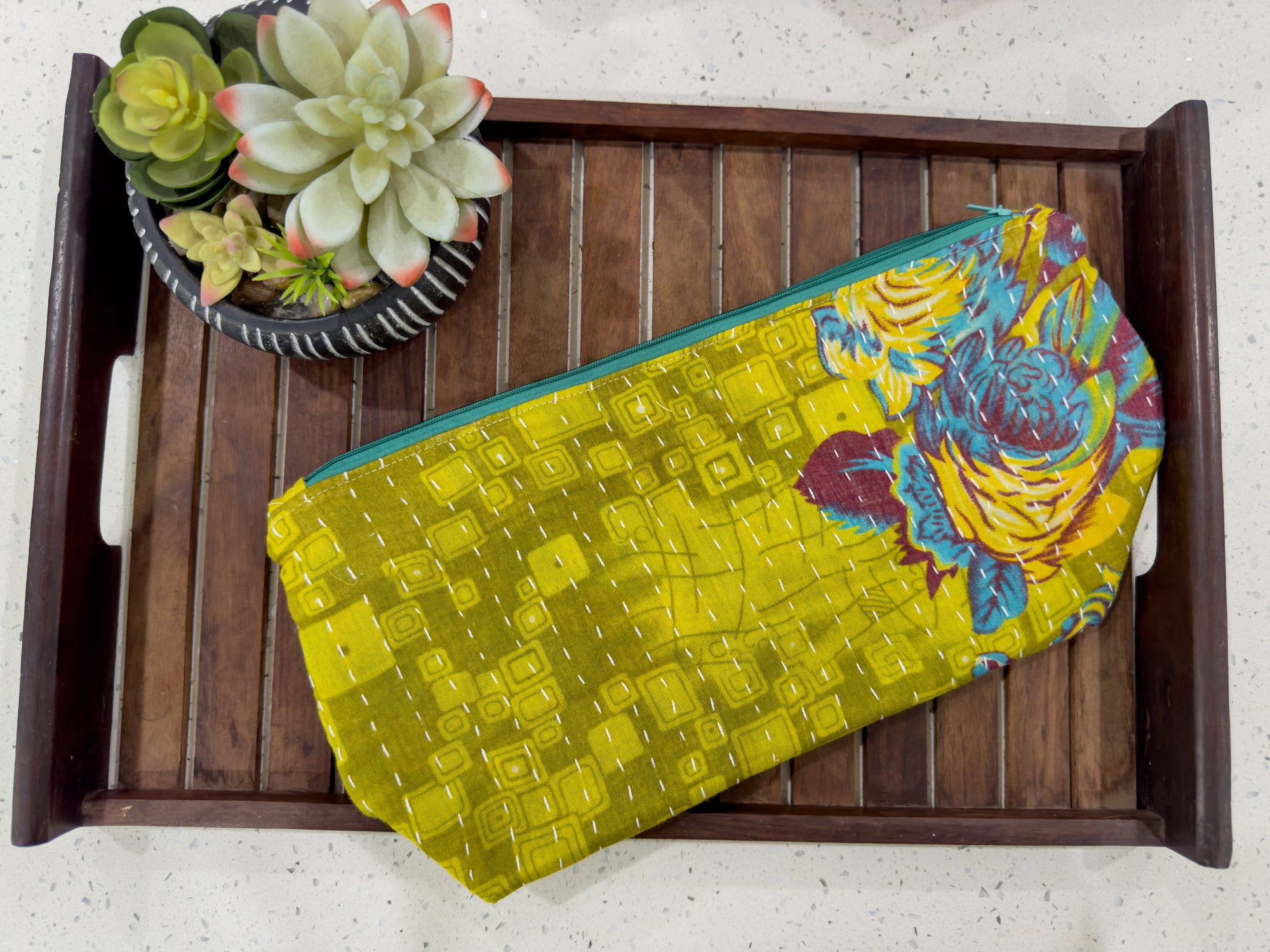 a wooden tray with a yellow bag and a succulent plant