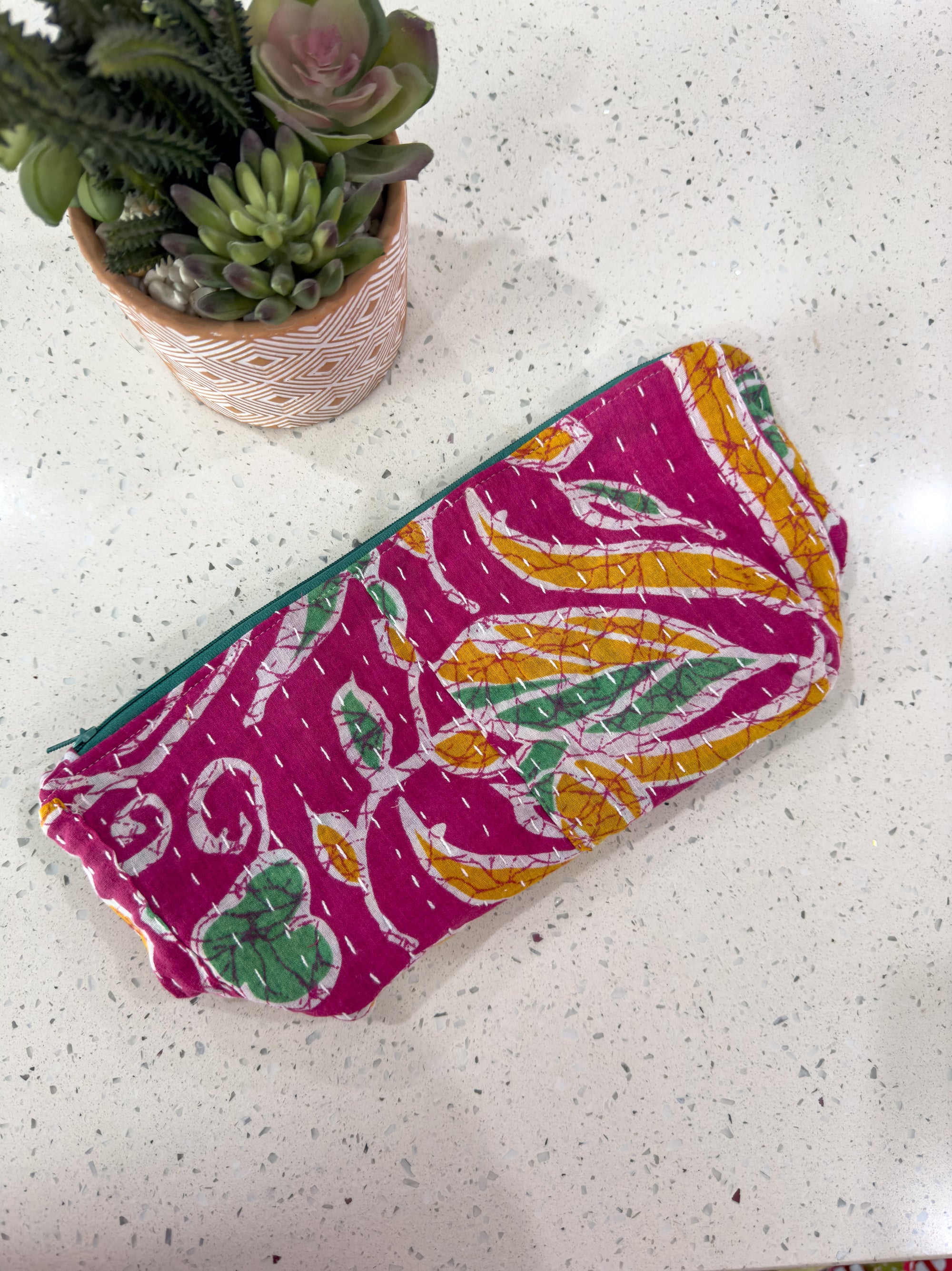 a purse sitting on top of a table next to a potted plant