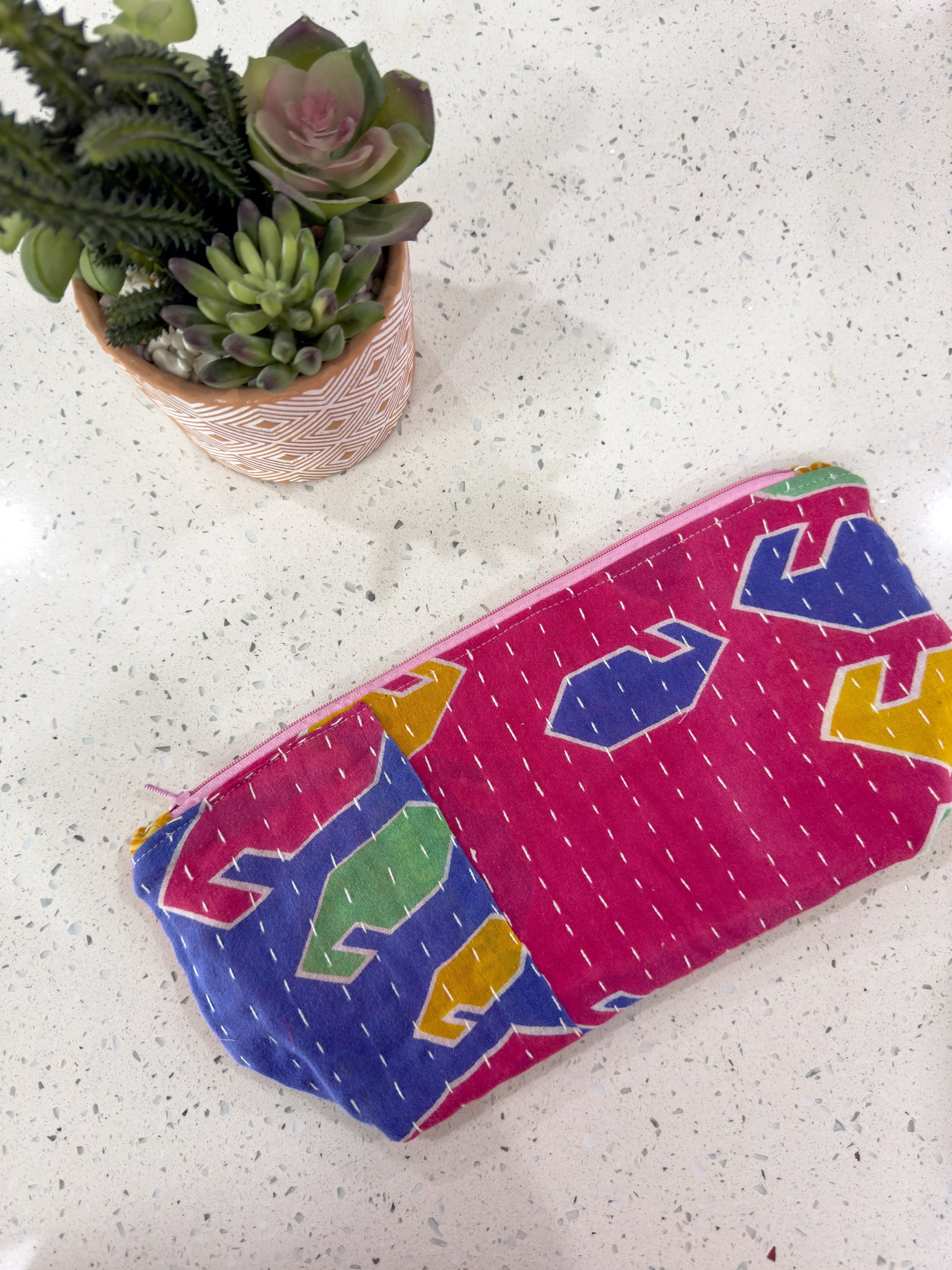 a colorful case sitting on top of a table next to a potted plant