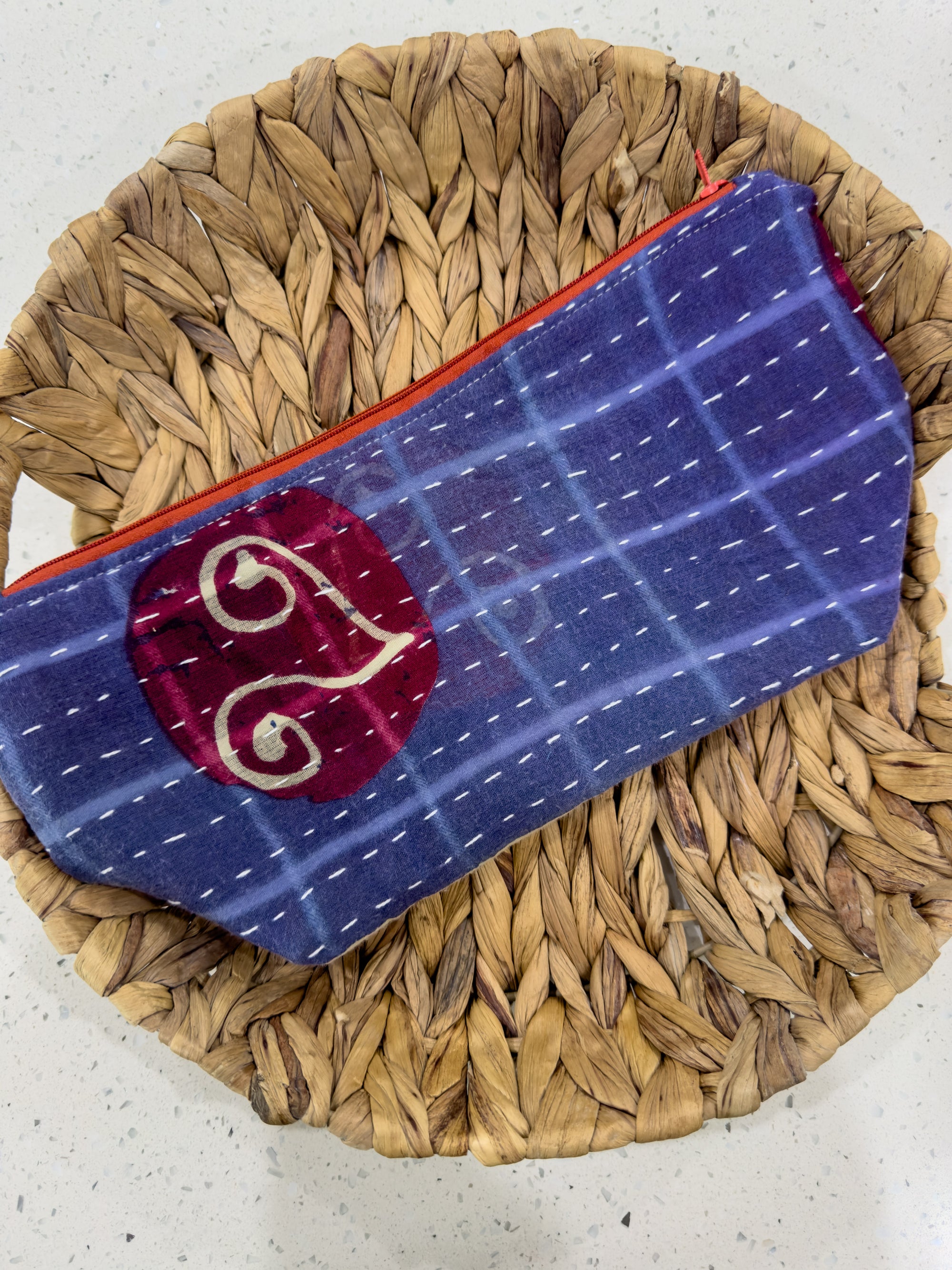 a blue and red purse sitting on top of a woven basket