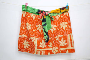 Handmade Kantha apron crafted from recycled sari fabric with colorful patchwork and traditional running stitches.
Vibrant boho kitchen apron made with upcycled cotton saris, pleated design, and a wide waistband that ties into a bow.