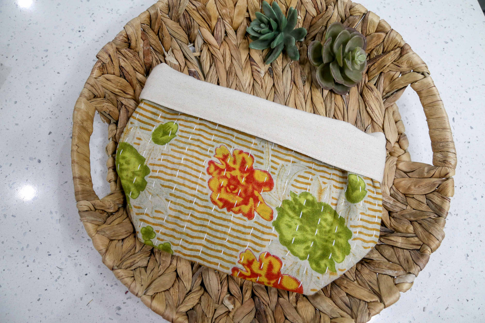 Tan with red, yellow, and green florals. Handmade Kantha basket with vibrant stitching and traditional saree patterns, perfect for storage, organizing, or adding a pop of color and style to any room.