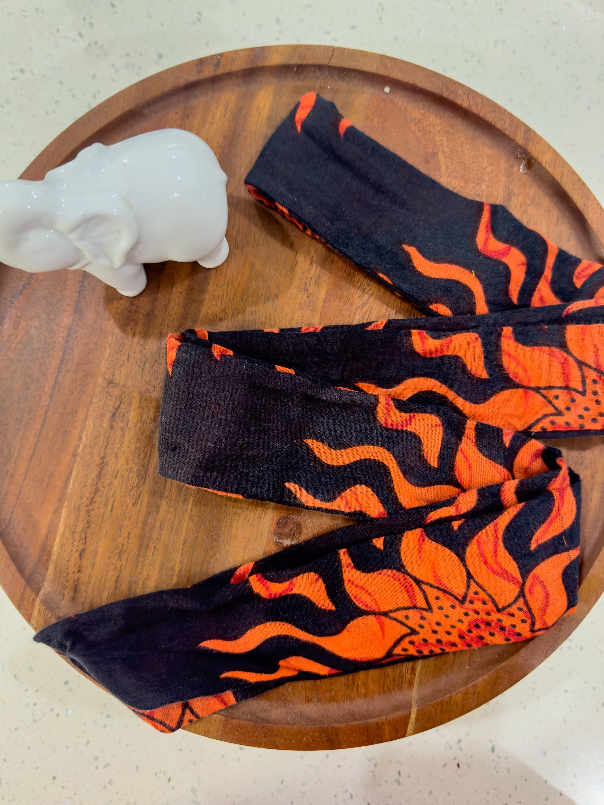 a pair of gloves sitting on top of a wooden plate