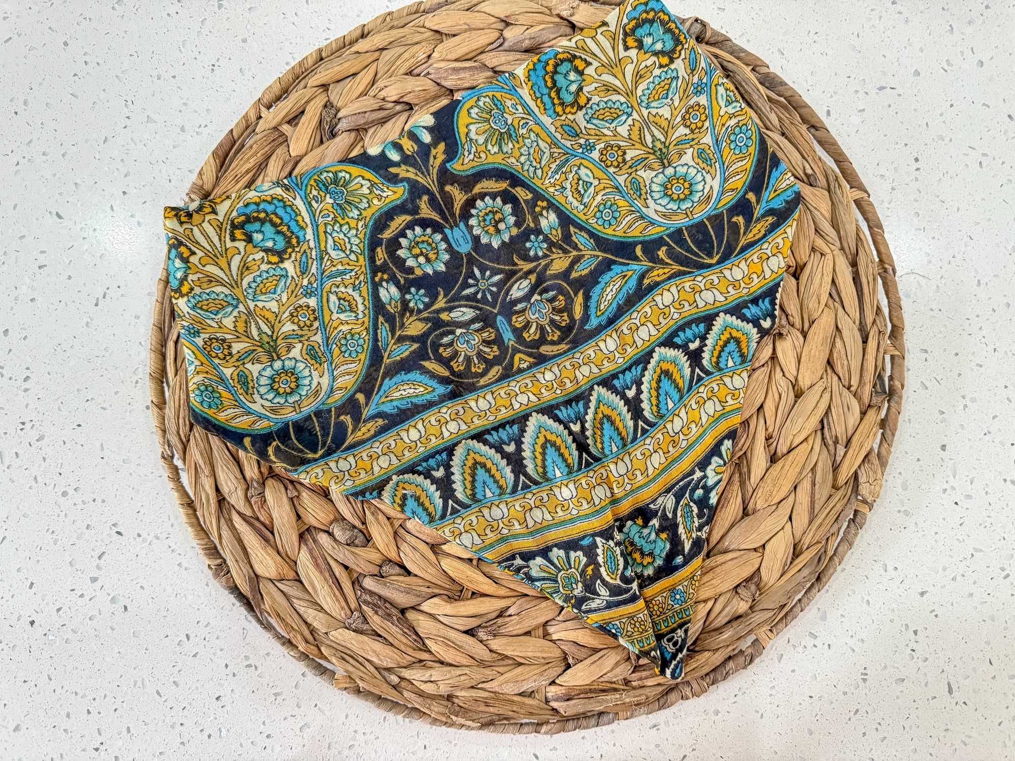 a woven basket with a blue and yellow paisley design