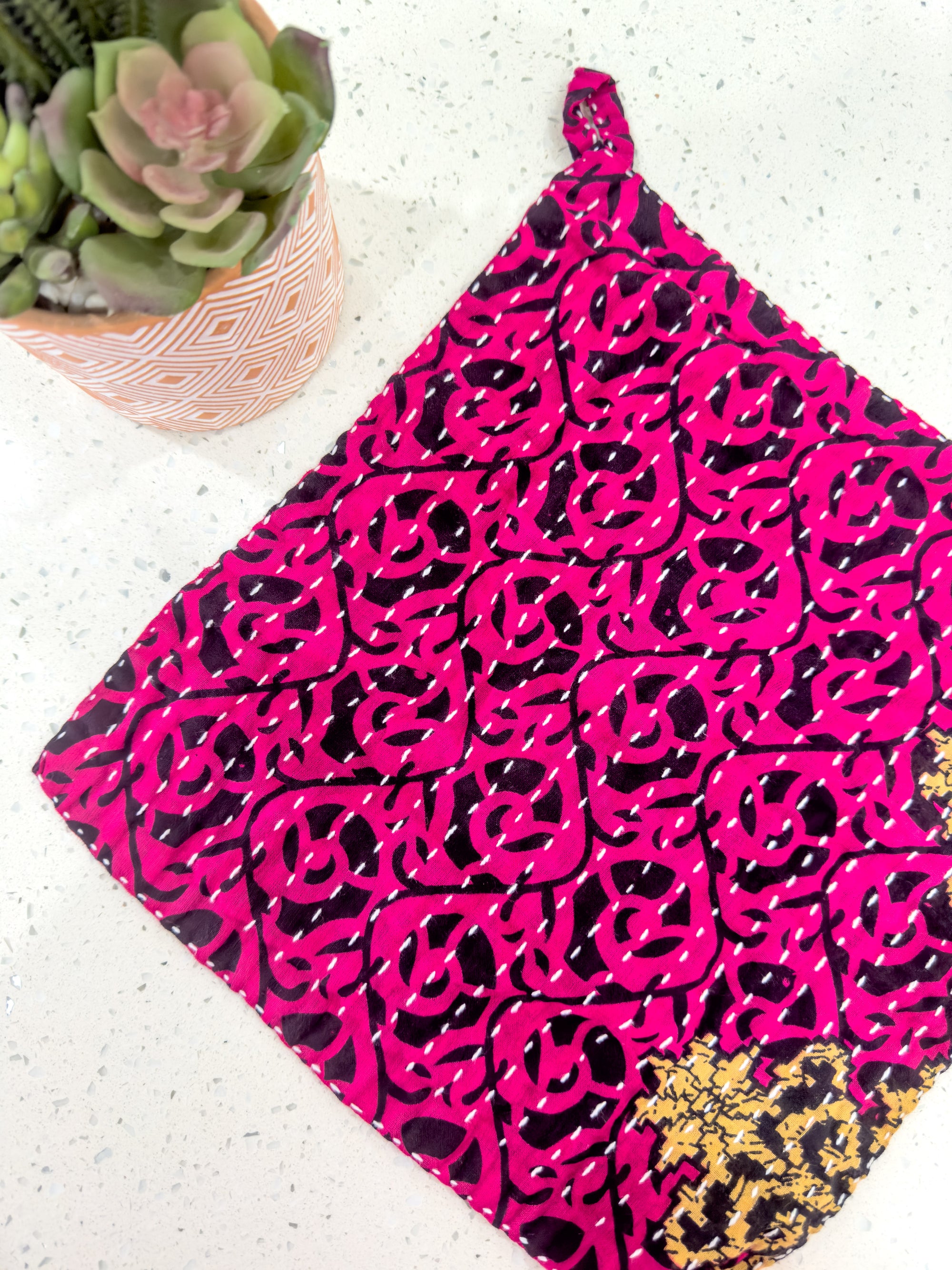 a close up of a cloth on a table near a potted plant