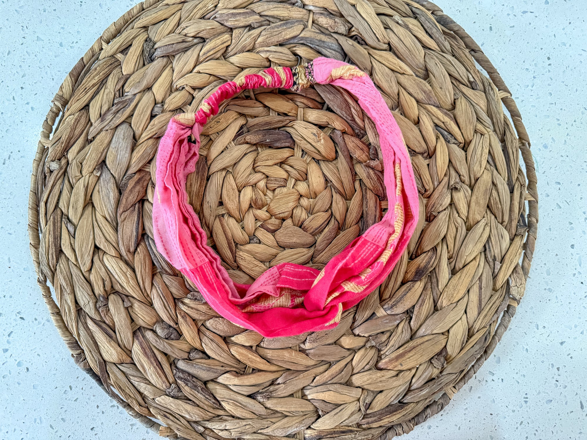 a straw hat with a pink scarf around it