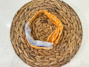 a yellow and blue scarf on top of a woven basket