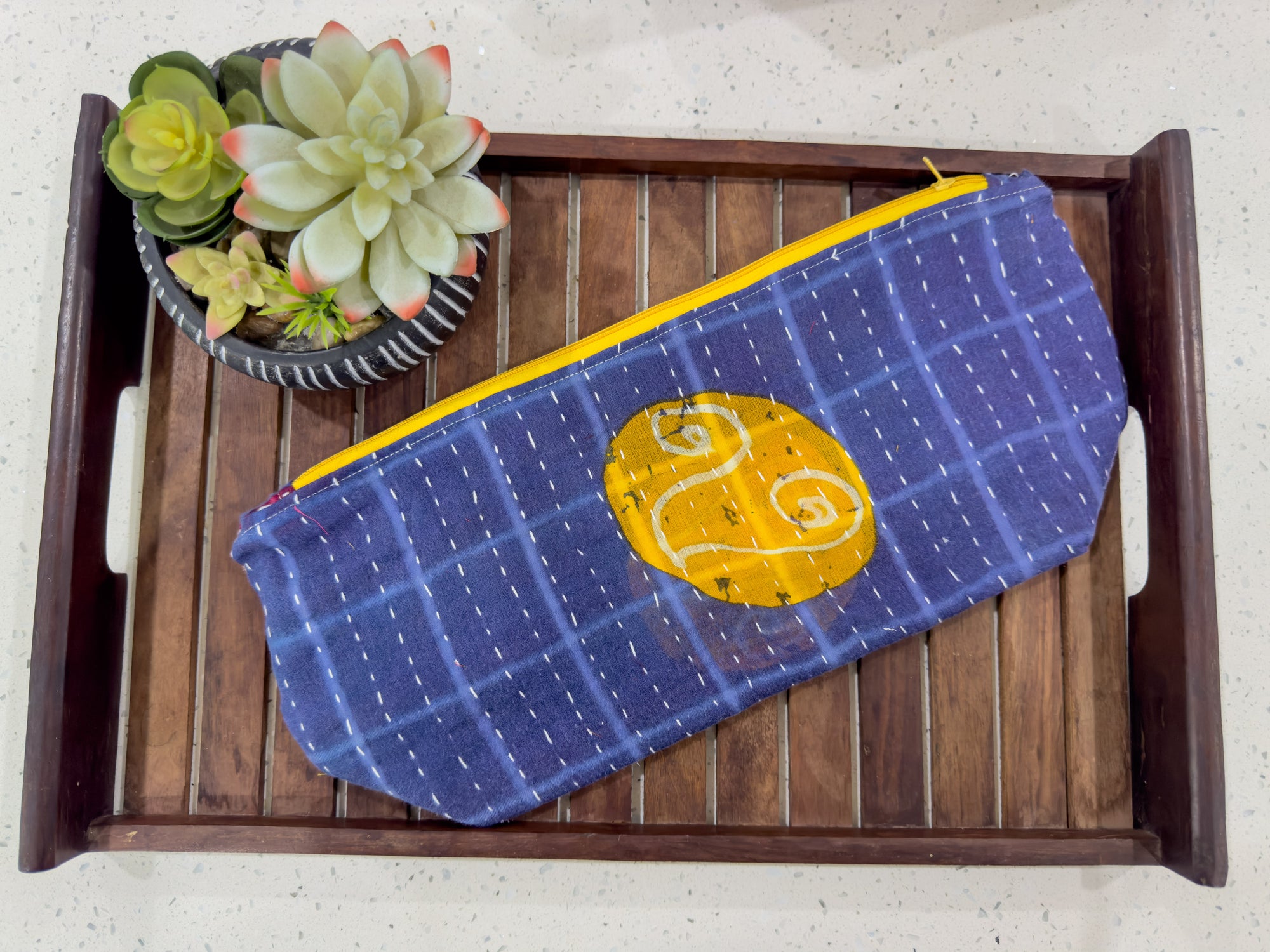 a blue and yellow purse sitting on top of a wooden tray