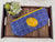a blue and yellow purse sitting on top of a wooden tray