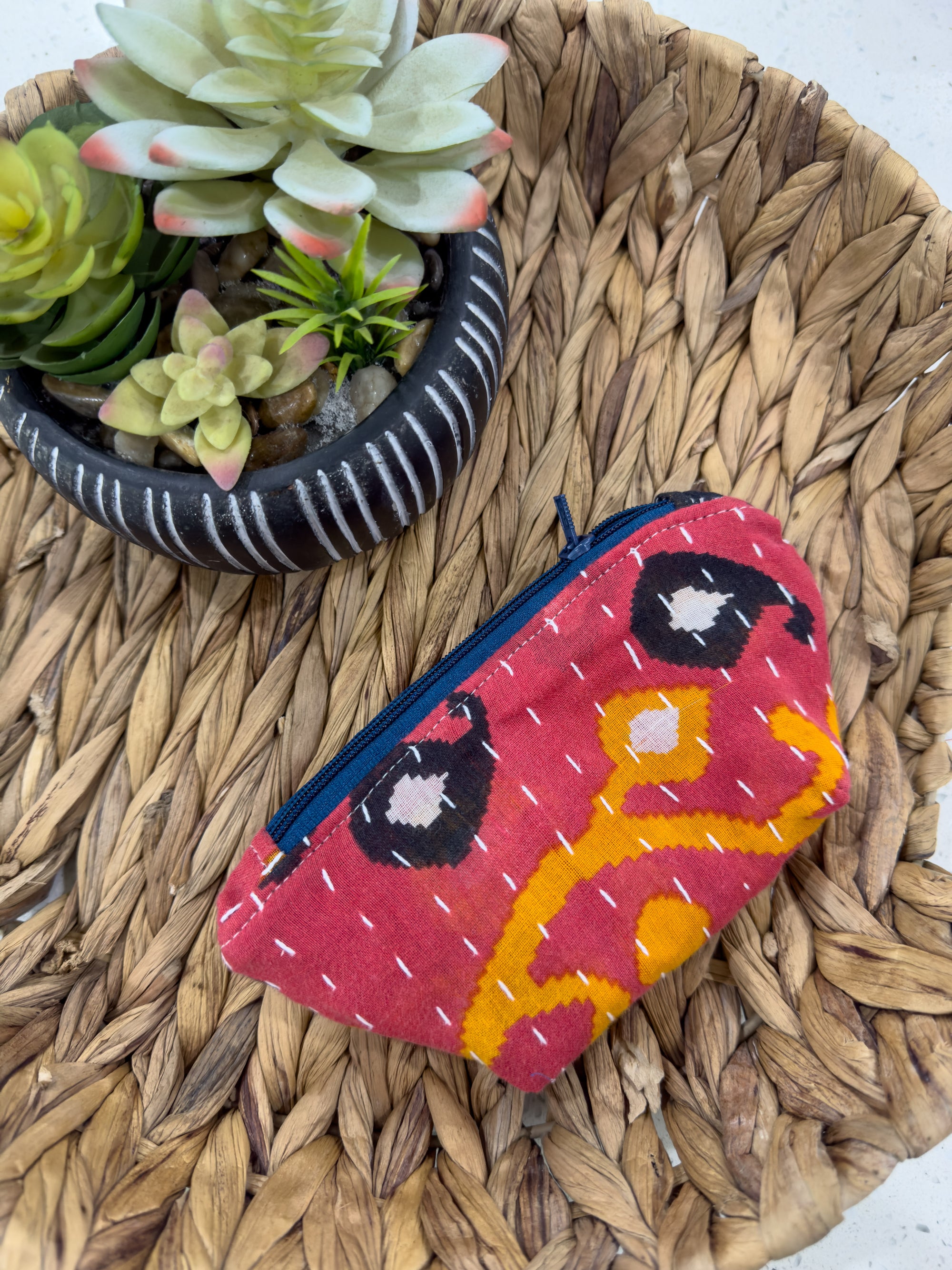 a small purse sitting on top of a table next to a potted plant