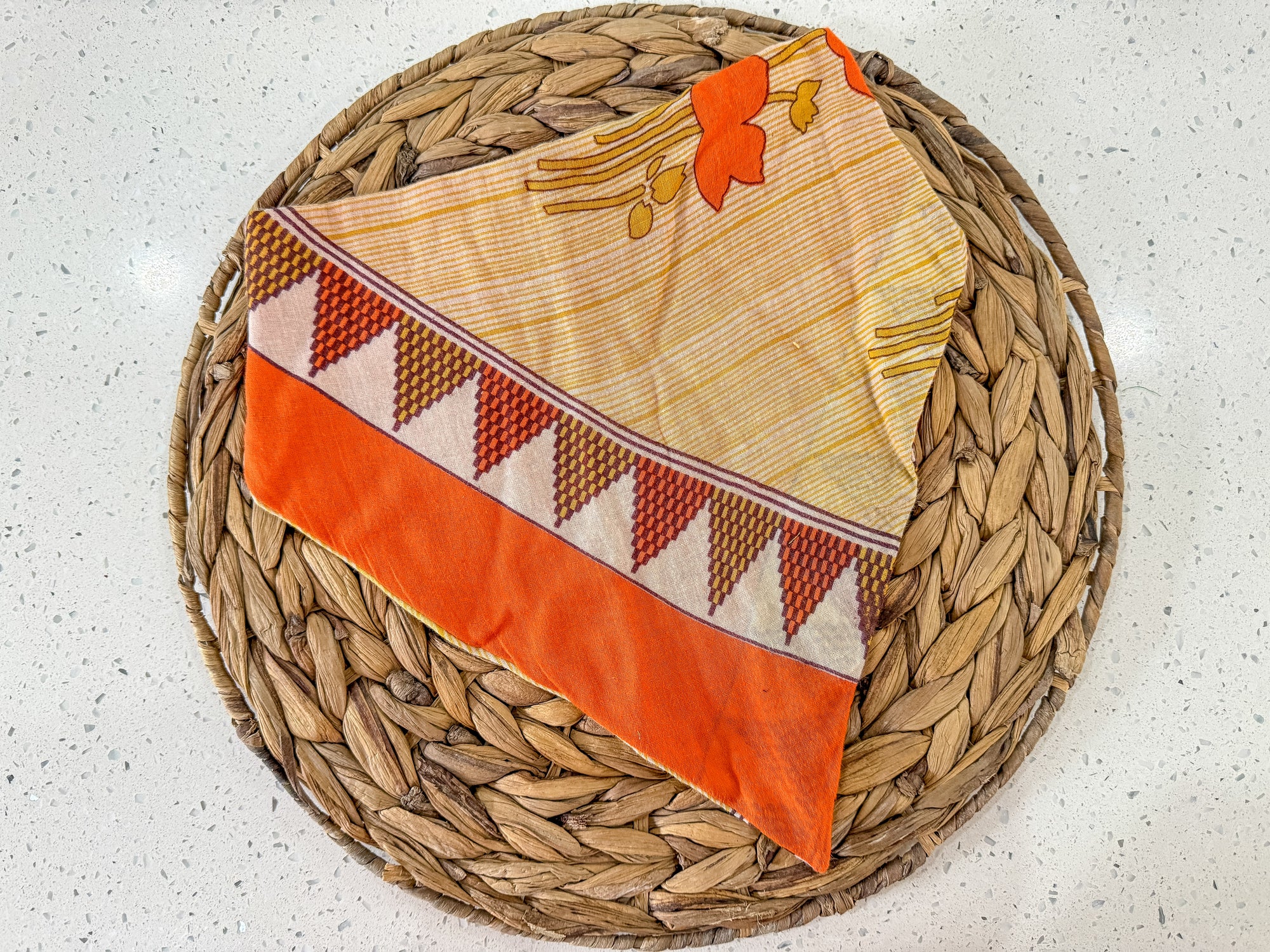 a woven basket with an orange and white cloth on it