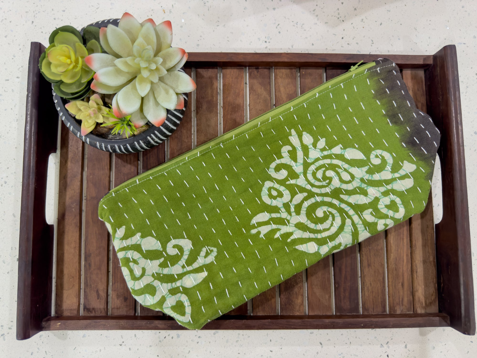 a green and white towel sitting on top of a wooden tray
