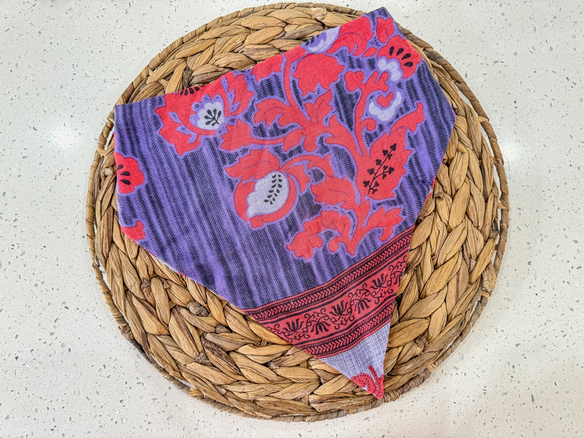 a basket with a purple and red cloth on top of it