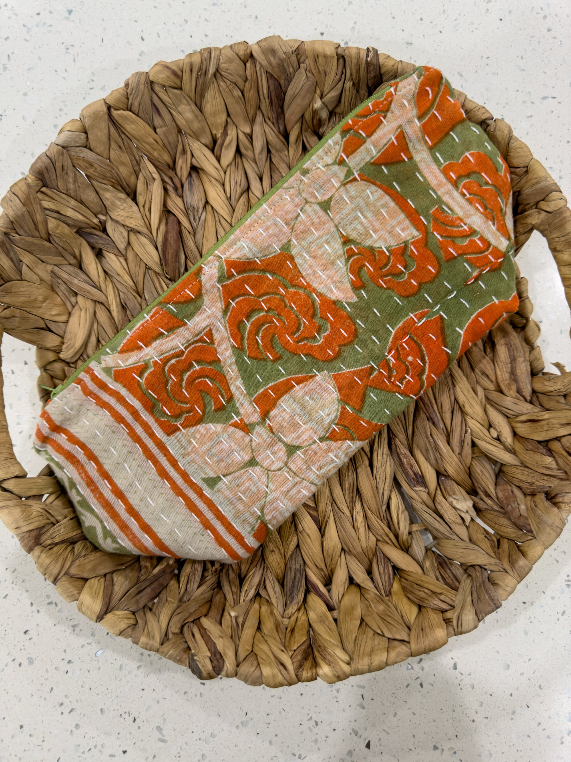 a woven basket with an orange and green design on it