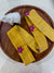 a wooden plate topped with yellow cloth and a white vase